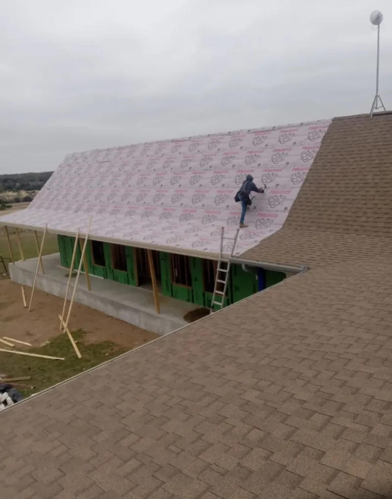 Worker preparing underlayment for a metal roof installation in Zephyrhills
